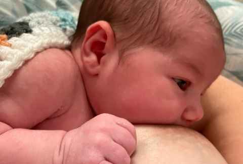 Baby attached to the breast and breastfeeding