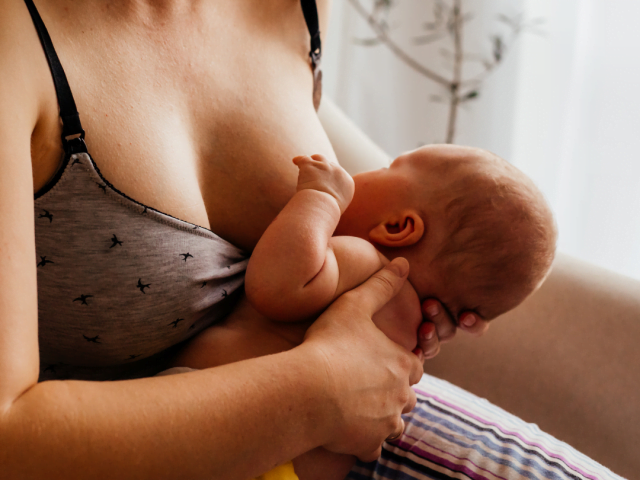Positioning baby at the breast, holding close and supporting behind the shoulders