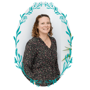 Liz Farrant leaning against a white wall and smiling at the camera
