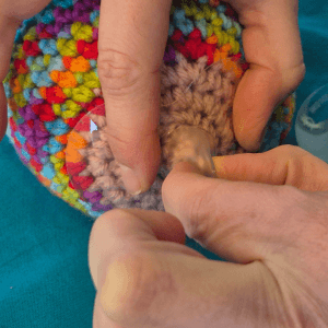 Taking hold of the nipple part of the shield and drawing it out, whilst your other hand holds the edges of the shield against your breast. This will draw your nipple into the shield