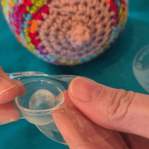 Demonstrating how to dimple the nipple shield in preparation for applying. Knitted breast in the background